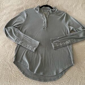 Casual grey tee with functional snap button detail on sleeves and collar.